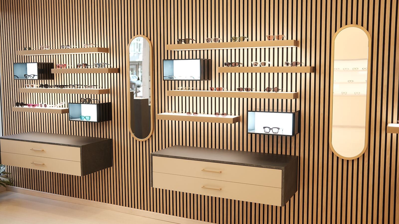 Home La parete delle collezioni di Ottica Casaccia, con mensole, vetrinette e specchi ovali